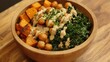 © isrofiyah - A vegan Buddha bowl with sweet potatoes, chickpeas, kale, and tahini dressing, served in a natural bamboo bowl
