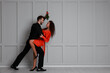 © New Africa - Lovely couple dancing under mistletoe bunch near light grey wall. Space for text