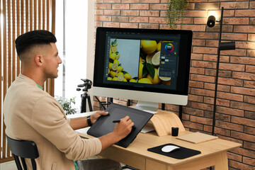Fototapete - Professional retoucher working on graphic tablet at desk in office