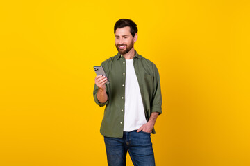 Aufkleber - Portrait of nice young man use smart phone wear khaki shirt isolated on yellow color background