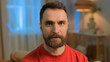 © Yuliia - Caucasian adult man close up portrait bearded millennial 30s guy husband dad father Caucasian family male serious sad alone homeowner tenant pensive worried tired looking at camera headshot at home
