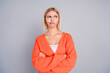 © deagreez - Portrait of nice young girl folded arms look empty space orange cardigan isolated on grey color background