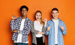 © Prostock-studio - Diverse classmates pointing fingers at themselves, posing to camera over orange studio background