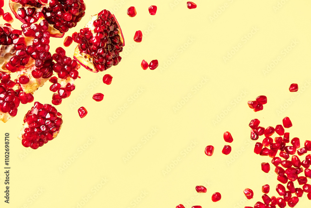 Flying fresh pomegranates with seeds on yellow background