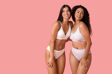 Beautiful young happy body positive women on pink background