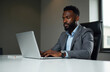 © Родион Бондаренко - African American businessman in business suit working on laptop