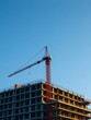 © heinng - Construction Crane at Sunset Over New Building. AI Generated