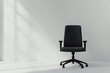 © padungsak - A sleek black office chair positioned in a minimalist room with soft shadows cast by natural light.