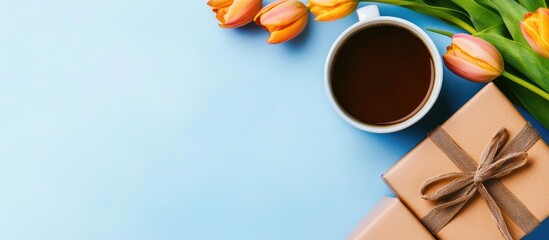 Aufkleber - Coffee cup gift box and tulip bouquet on blue tabletop creating an inviting spring atmosphere perfect for celebrations or special occasions.