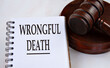 © Zhanna - WRONGFUL DEATH - words in a white notebook with a judge's gavel in the background