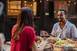 © PintoArt - Multiracial couple enjoying dinner together outdoors,