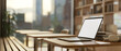 © bongkarn - A side view of a laptop on a wooden table in a cozy minimalist coffee shop or library.