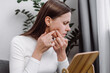 © Yura Yarema - Dermatology concept. Close up of sad young woman looking in mirror, allergy presenting an allergic reaction from cosmetic, red spot or rash on face. Beauty care from skin problem by medical treatment