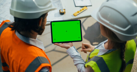 Technical Inspector and Construction Manager Using a Tablet with Green Screen Mock Up Template. Female Specialist Using Computer to Oversee the Project at a Construction Site