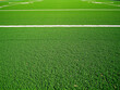 © Vectplus - Bright green artificial turf field used for various sports in a sunny outdoor environment