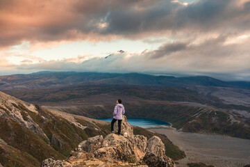 Wall Mural - Asian hiker woman standing on Tama Lakes viewpoint with Mount Ruapehu hiding in the cloud at Tongariro national park, New Zealand