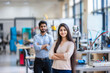 © PRASANNAPIX - young indian man and woman standing at robotics lab