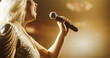© Gorodenkoff - Close Up Portrait of a Blonde Musician Using a Microphone to Sing a Powerful Pop Song in a Beautiful Warm Lit Venue. Female Music Performer Putting On a Show at a Concert Stage