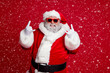 © deagreez - Portrait of attractive crazy Santa showing horn symbol having fun newyear occasion isolated over bright red color background