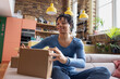 © ReeldealHD images - Happy young African American opening an online order at home