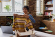 © ReeldealHD images - Young African American female vintage fashion business owner packing an online order to ship