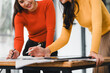 © kenchiro168 - Collaborative women working on project, discussing ideas and taking notes. Their colorful sweaters add vibrant touch to workspace, enhancing creativity and teamwork