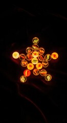 Wall Mural - glowing marbles arranged in star shape on dark background