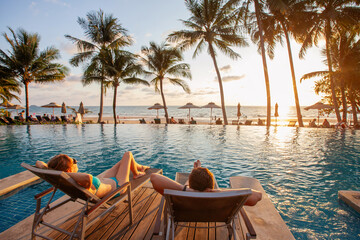 Wall Mural - couple on holidays, beach vacation in luxury hotel near swimming pool at sunset