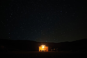 starry night sky with a luminous star shining over a stable; the holy family's silhouettes radiating