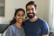 © Markus Schröder - Portrait of a smiling indian couple in their 20s wearing a moisture-wicking running shirt in front of crisp minimalistic living room