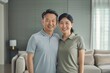 © Markus Schröder - Portrait of a blissful asian couple in their 30s wearing a breathable golf polo over crisp minimalistic living room