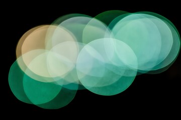 Poster - Vibrant Abstract Light Bokeh in Green and Gold Against a Dark Background Featuring Soft Focus Shapes with a Dreamy and Ethereal Quality for Creative Projects