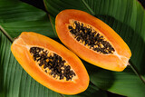 Juicy papaya fruit cut in half, with seeds and bright orange flesh top view. This photo highlights the freshness and nutritional value of papaya fruit, ideal for healthy food background.