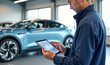 © Radorog. - an auto mechanic holds a tablet in his hands and performs car diagnostics