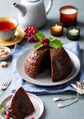 Wall Mural - Christmas pudding, fruit cake with cup of tea. Traditional festive dessert. Grey background.