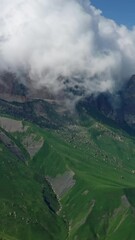 Wall Mural - aerial view on caucasus mountains under epic moving clouds, kabardino-balkaria, russia. vertical vid