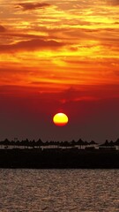Wall Mural - resort beach with parasol and beautiful sea sunrise. vertical video