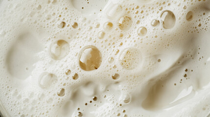 Wall Mural - Glass of beer with foam on top. The foam is white and the beer is brown. The glass is half full