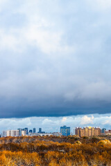 Wall Mural - large dark blue cloud over colorful city park