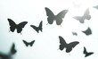 © Olha - A group of butterflies in silhouette, flying upwards in a gentle arc formation, on a bright white background