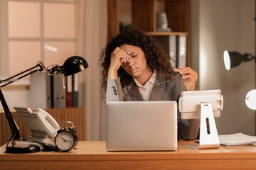 Wall Mural - Tired African-American businesswoman with eyeglasses trying to meet deadline in office at night