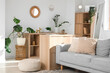 © Pixel-Shot - Interior of light living room with grey sofa, shelf units and plants