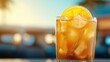 © altitudevisual - Close-up of a refreshing orange cocktail with ice cubes in a glass garnished with an orange slice, set against a blurred outdoor background.