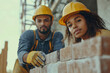 © Centric  - Construction workers laying bricks while building a wall at a construction site