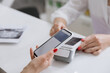 © bondvit - Contactless smartphone payment at a clinic reception desk for a seamless transaction