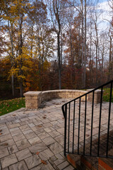 Wall Mural - A serene backyard featuring a curved stone patio surrounded by vibrant autumn foliage, creating a peaceful outdoor space ideal for relaxation and nature appreciation.