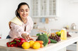 © Prostock-studio - Healthy Food To Boost Your Immune System. Beautiful smiling young woman cooking fresh organic salad at home in modern kitchen, reaching for vegetables, copy space. Diet, Food And Lifestyle Concept