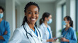 © Mr. Bolota - Black Latina Woman Doctor Smiling with Confidence, Surrounded by Fellow Medical Professionals, Showcasing Teamwork, Expertise, and Compassion in Healthcare.