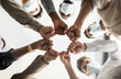 © Prostock-studio - Success And Teamwork Concept. Below view of young diverse group of business people in protective medical masks making fist bump standing in circle. Workers do fist pump together celebrating good deal