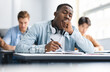 © Prostock-studio - Tired black student yawning sitting at desk in classroom. African American youth exhausted from getting ready for test or writing coursework, feeling sleepy during lecture in highschool. Lack of sleep